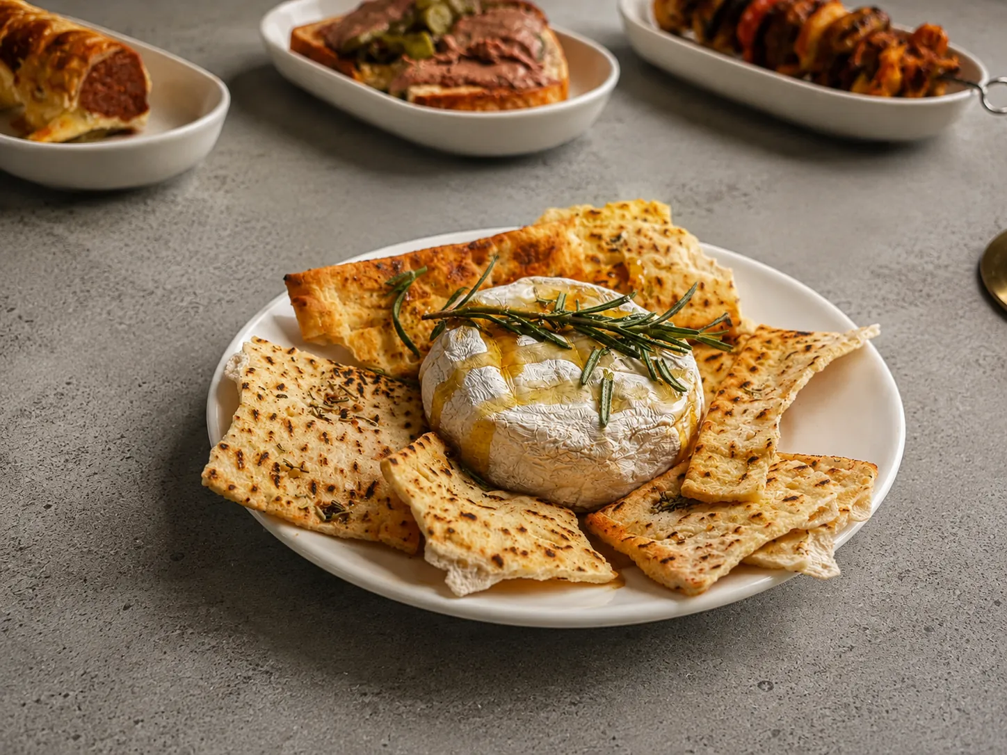 Honey-drizzled baked camembert with toasted flatbread from the galley on a Gold Coast sailing voyage