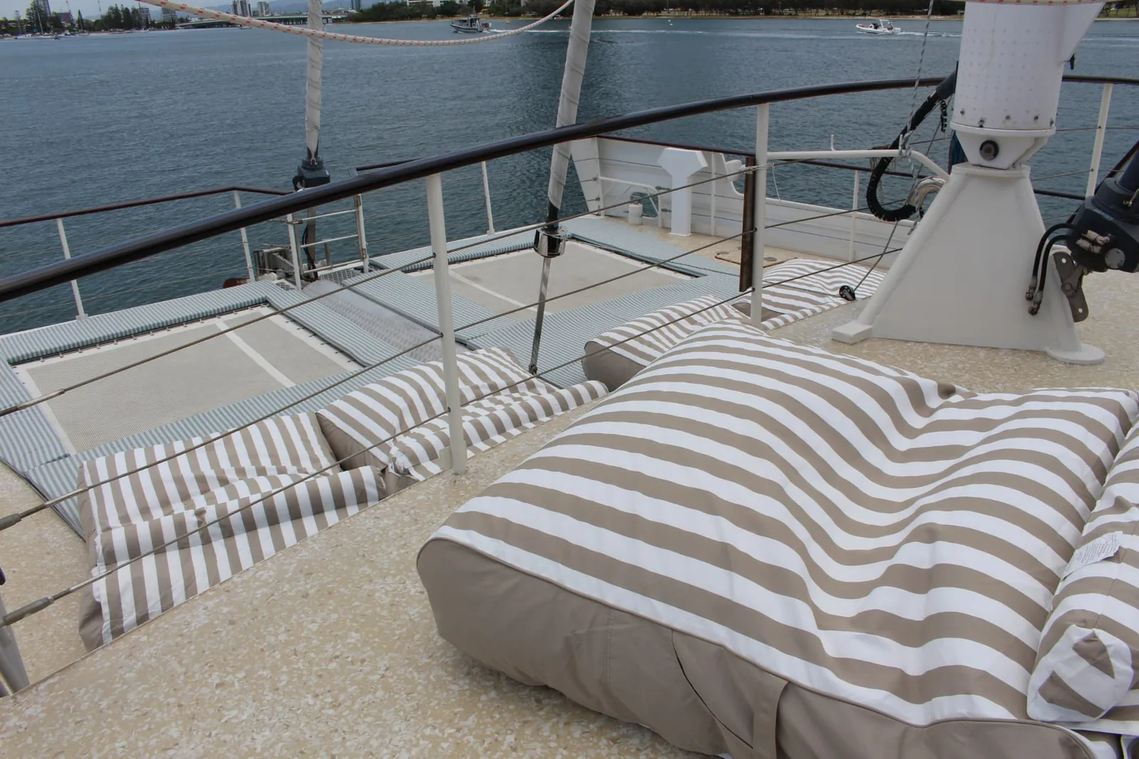 Striped beanbags and trampoline nets on the bow of Gold Coast sailing superyacht VOYŌ on the Broadwater