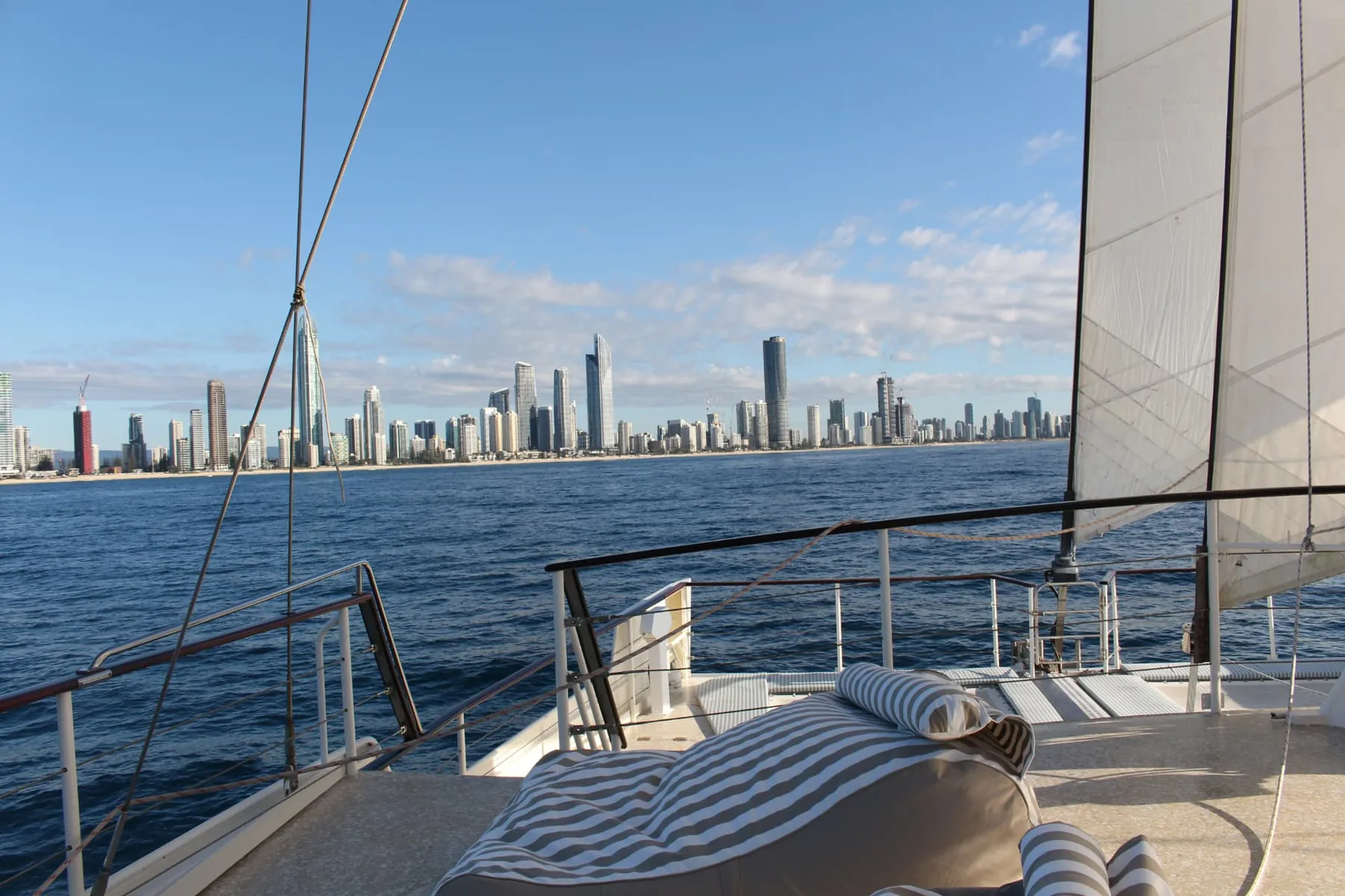 View from the bow toward Surfers Paradise on a Gold Coast sailing voyage aboard VOYŌ